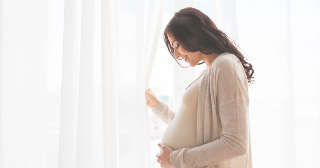 a pregnant woman looking at her belly